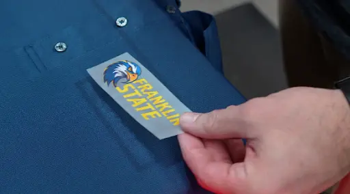 Hand applying direct to garment design to a shirt